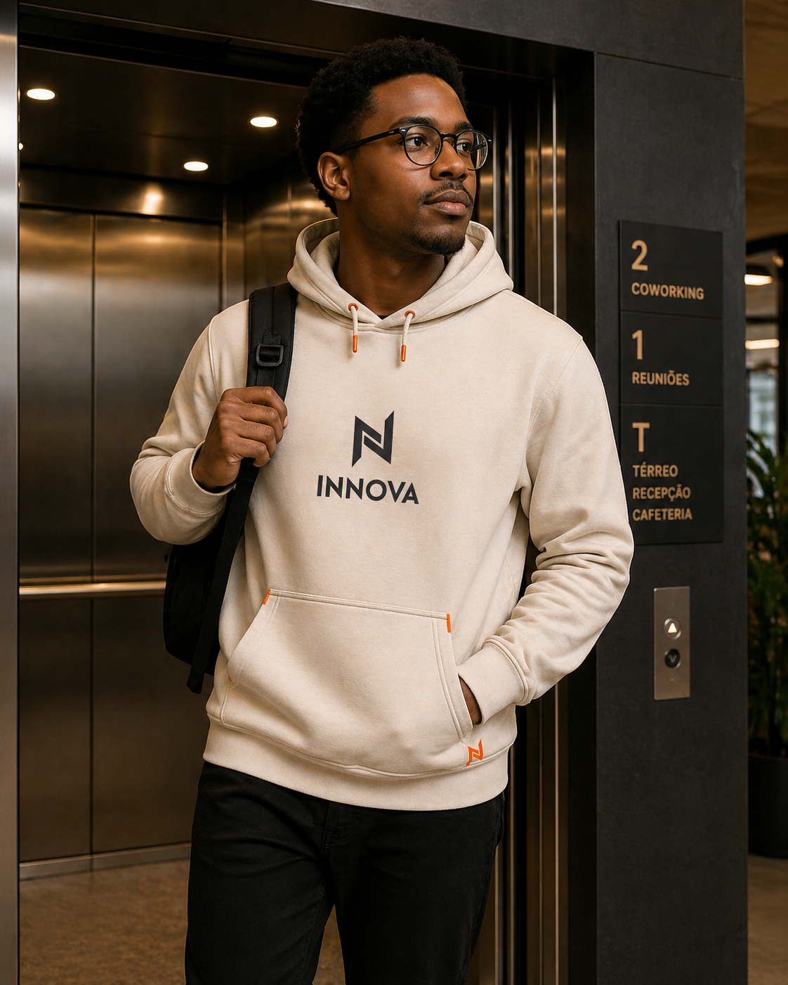 Colaborador com moletom bege Innova em frente ao elevador do edifício