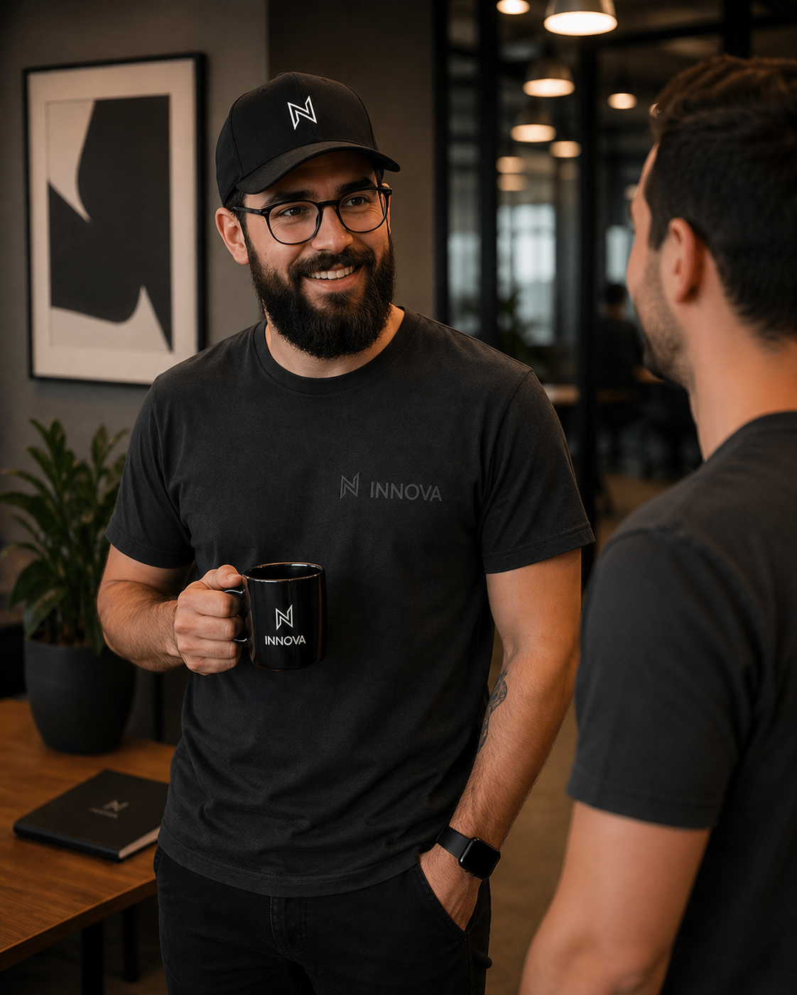 Colaboradores conversando no escritório, vestindo camiseta e boné Innova